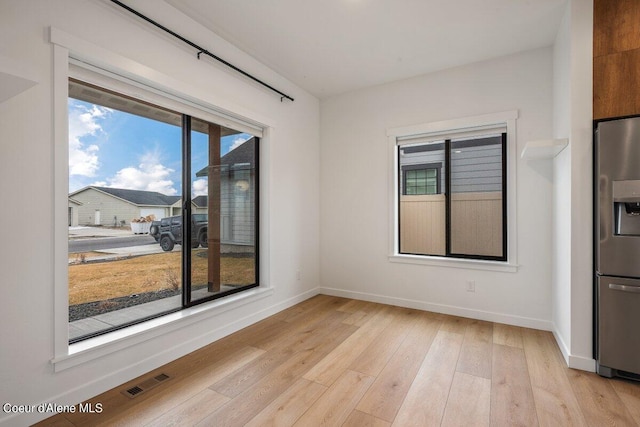 unfurnished room with plenty of natural light and light wood-type flooring