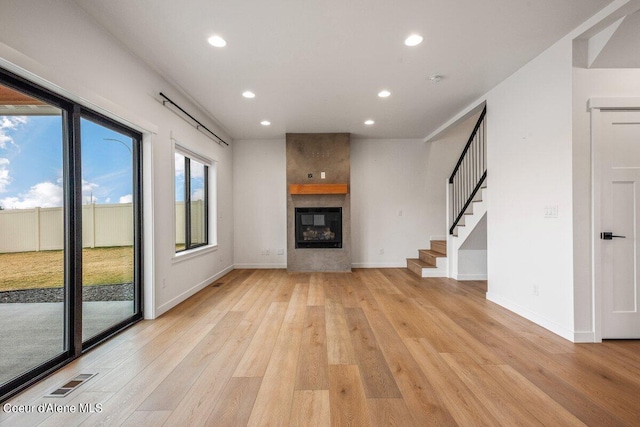 unfurnished living room featuring a fireplace and light hardwood / wood-style flooring