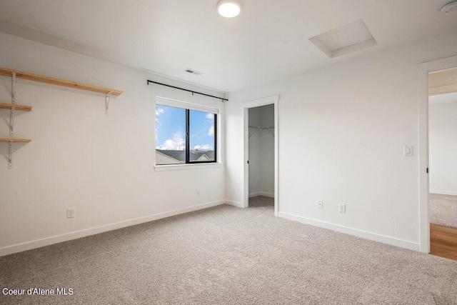 unfurnished bedroom with a walk in closet, carpet floors, and a closet