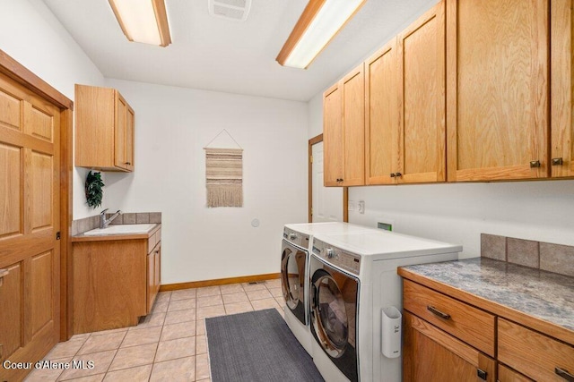 washroom with sink, cabinets, washer and clothes dryer, and light tile patterned floors