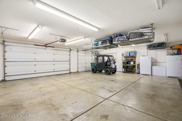 garage featuring a garage door opener and white refrigerator