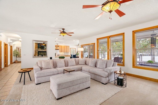 tiled living room with a textured ceiling and ceiling fan