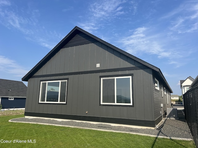 view of side of property with a yard and cooling unit