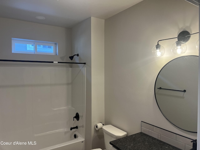 full bathroom featuring washtub / shower combination, vanity, and toilet