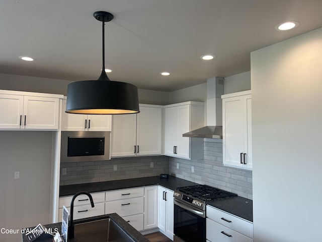 kitchen with appliances with stainless steel finishes, backsplash, wall chimney exhaust hood, decorative light fixtures, and white cabinets