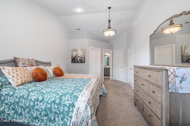 carpeted bedroom featuring ensuite bath and lofted ceiling