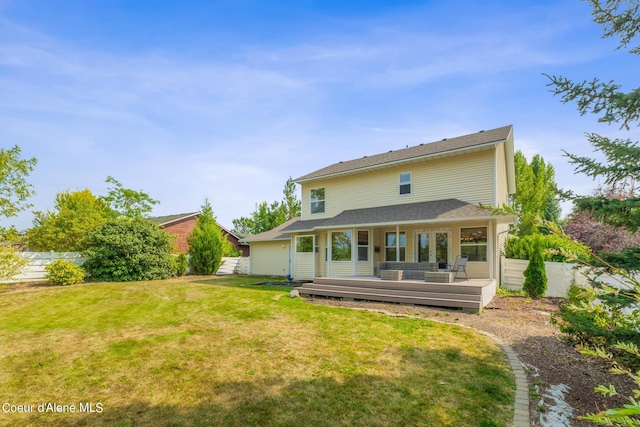 rear view of house featuring a lawn and a deck