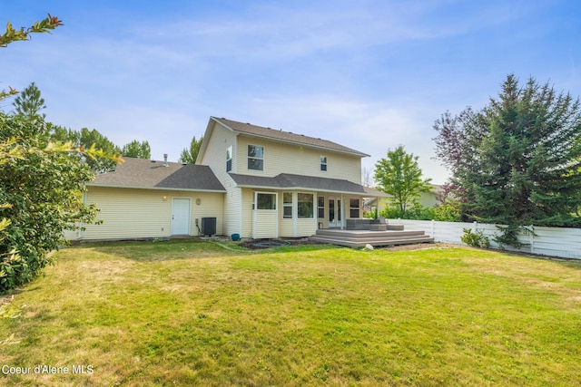 back of house featuring a lawn, a wooden deck, and central AC