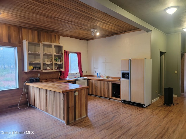 kitchen featuring white appliances, kitchen peninsula, light hardwood / wood-style flooring, butcher block counters, and wood ceiling