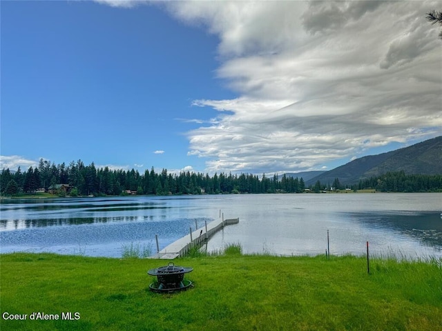 water view with a mountain view, a boat dock, and an outdoor fire pit