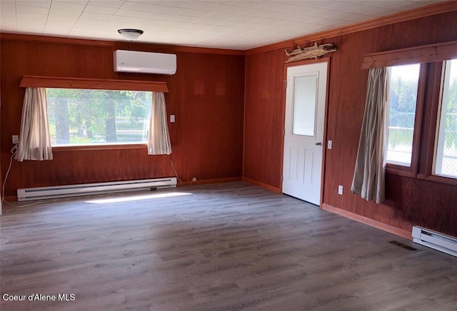 unfurnished room featuring a wall unit AC, baseboard heating, dark wood-type flooring, and crown molding