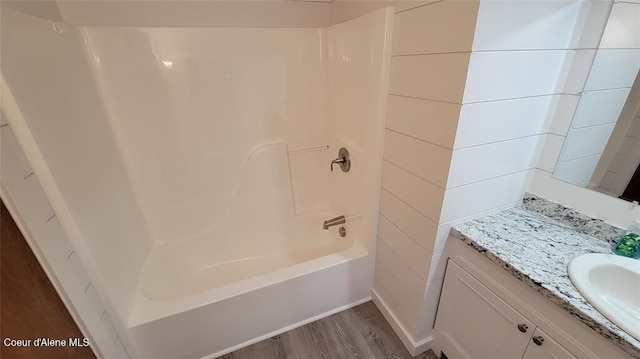 bathroom featuring shower / tub combination, hardwood / wood-style floors, and vanity