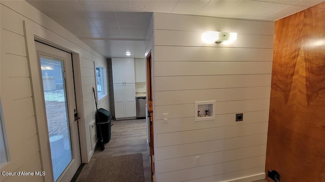 laundry area featuring electric dryer hookup, wooden walls, washer hookup, and wood-type flooring