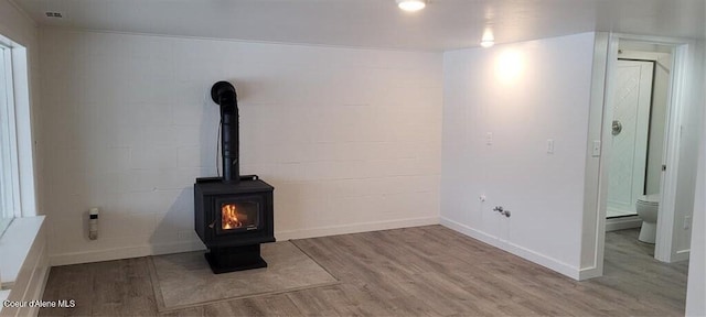 interior space with light hardwood / wood-style floors and a wood stove