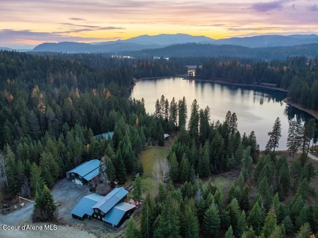 aerial view at dusk featuring a water and mountain view