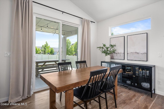 dining area featuring dark wood-type flooring and lofted ceiling