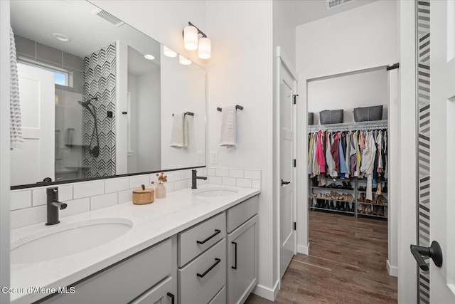 bathroom featuring vanity, wood-type flooring, and tasteful backsplash