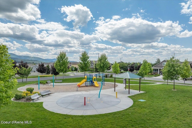 view of playground featuring a lawn and a mountain view