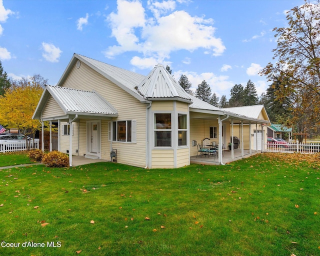 rear view of house with a patio and a lawn