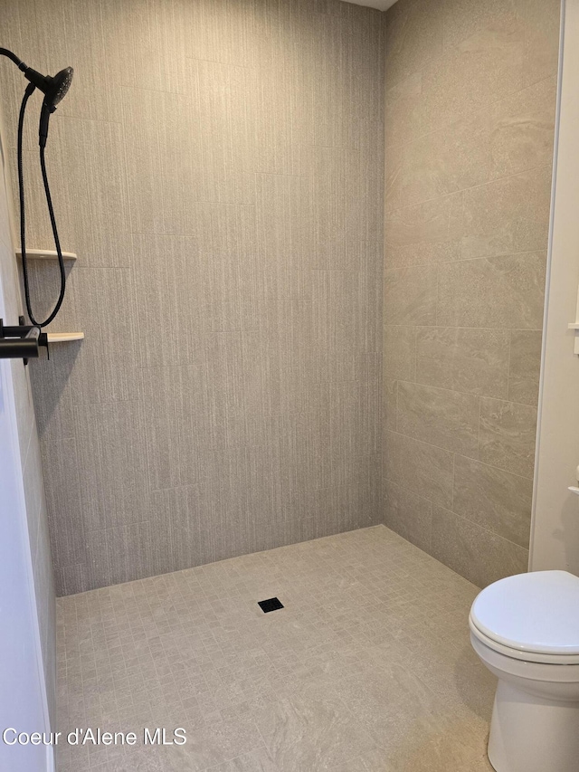 bathroom with toilet and a tile shower