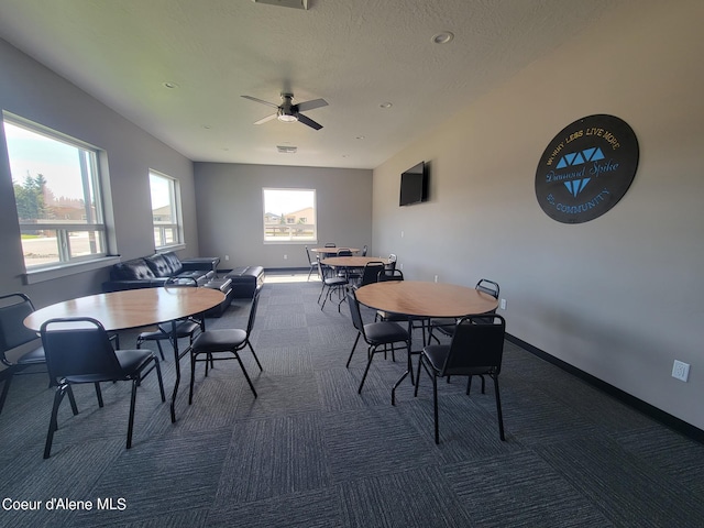 carpeted dining area with ceiling fan