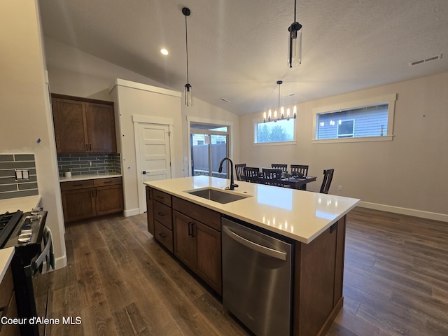 kitchen with dishwasher, a kitchen island with sink, hanging light fixtures, sink, and decorative backsplash