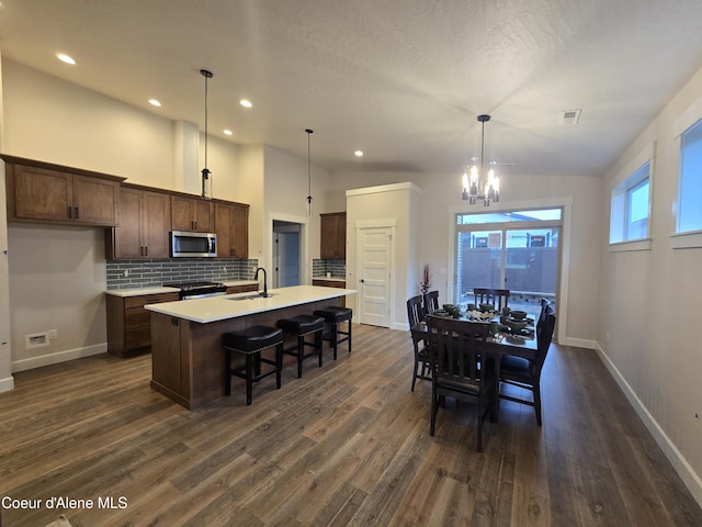 dining space featuring a chandelier, dark hardwood / wood-style floors, lofted ceiling, and sink