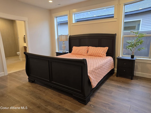 bedroom with wood-type flooring and connected bathroom