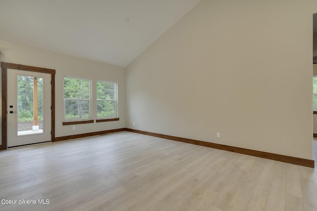 spare room featuring light hardwood / wood-style floors and high vaulted ceiling