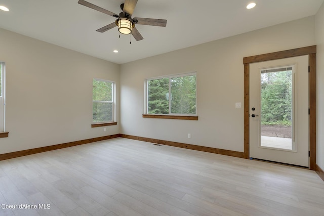 spare room with ceiling fan and light wood-type flooring