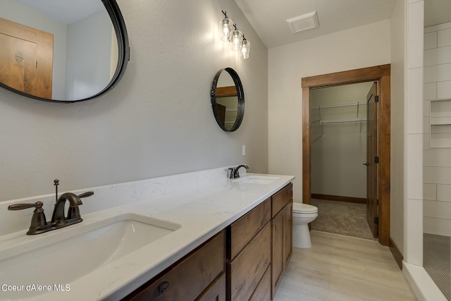 bathroom featuring hardwood / wood-style floors, vanity, toilet, and walk in shower