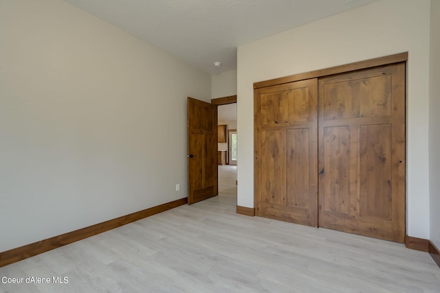 unfurnished bedroom with light hardwood / wood-style floors and a closet