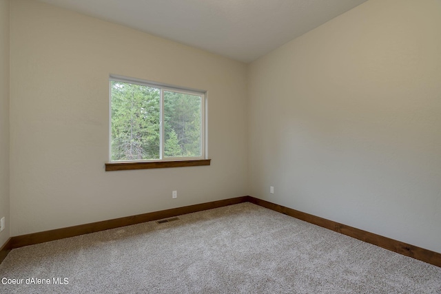 carpeted spare room with vaulted ceiling