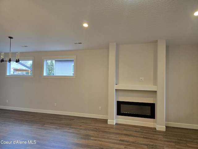 unfurnished living room featuring dark hardwood / wood-style floors and a textured ceiling