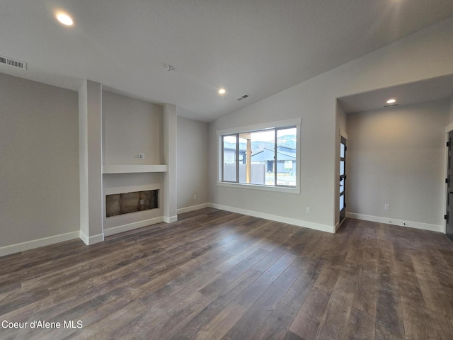 unfurnished living room with dark wood-type flooring, built in shelves, and vaulted ceiling