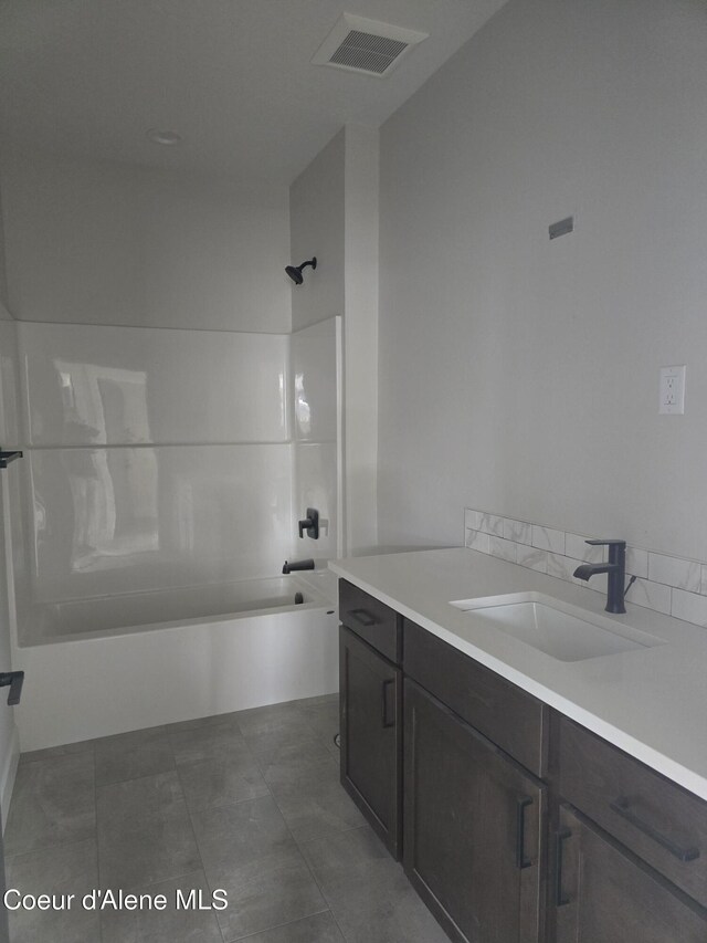 bathroom with tile patterned flooring, vanity, and  shower combination