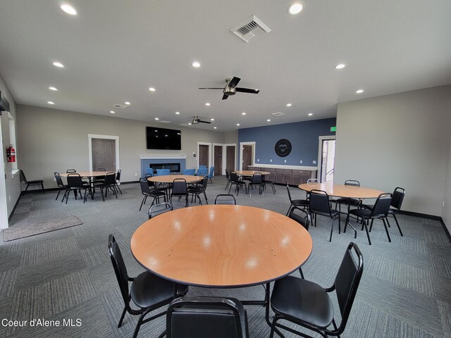 carpeted dining space with recessed lighting, visible vents, baseboards, and a glass covered fireplace