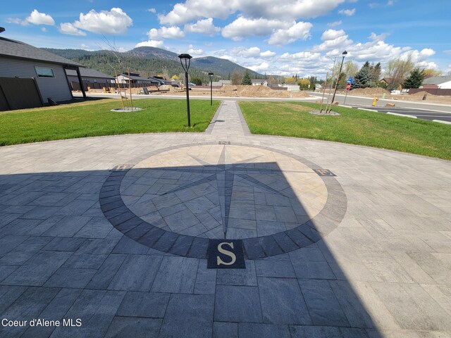 surrounding community with a yard, a patio area, and a mountain view