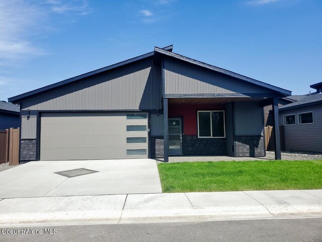 view of front of house with an attached garage, stone siding, and concrete driveway