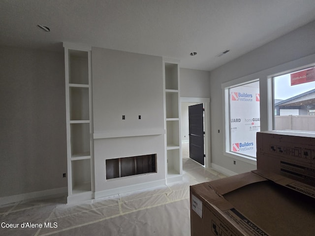 living area featuring built in features, visible vents, a fireplace, and baseboards