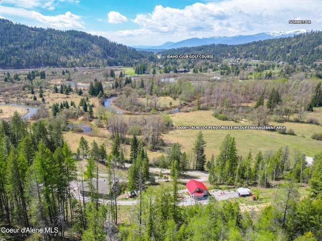 birds eye view of property with a wooded view and a mountain view