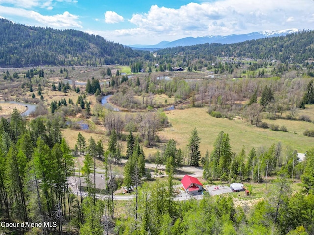 birds eye view of property with a mountain view and a forest view