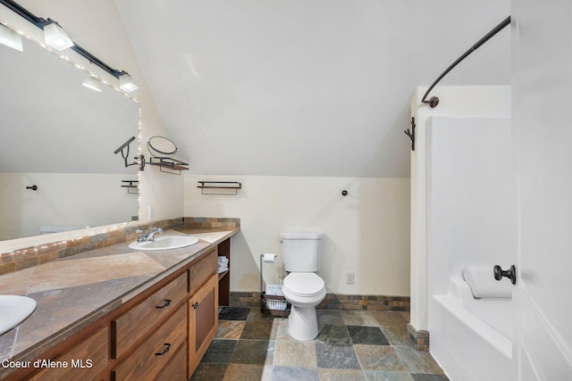 full bathroom with vanity, shower / bathing tub combination, vaulted ceiling, and toilet