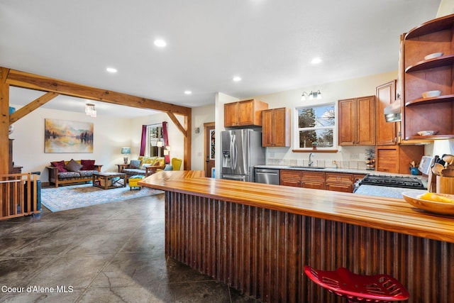 kitchen featuring appliances with stainless steel finishes, sink, wooden counters, kitchen peninsula, and beam ceiling