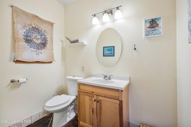 bathroom with tile patterned flooring, vanity, and toilet