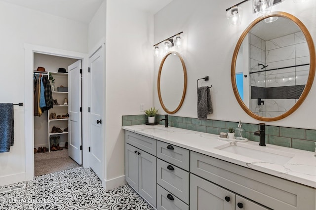 bathroom featuring tile patterned flooring, vanity, tasteful backsplash, and a shower with shower door