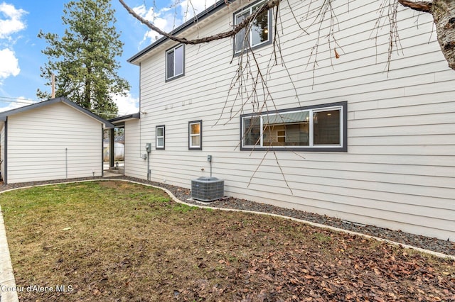 exterior space featuring a lawn, an outdoor structure, and central air condition unit