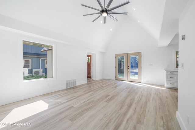 unfurnished living room with ceiling fan, french doors, high vaulted ceiling, and light hardwood / wood-style floors