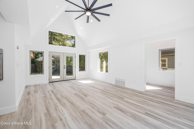 unfurnished living room featuring french doors, light hardwood / wood-style floors, high vaulted ceiling, and ceiling fan