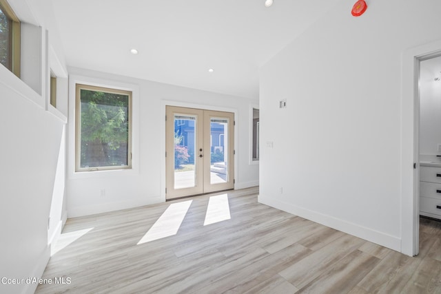 unfurnished room featuring french doors and light hardwood / wood-style floors